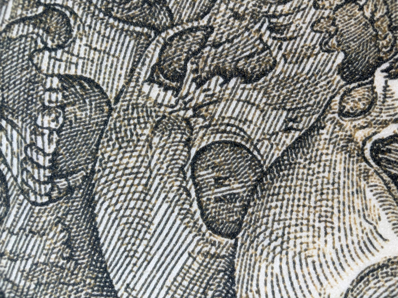 A long rectangular yoga mat featuring a detailed sepia-toned illustration of stacked human skulls, shown against a plain white background.